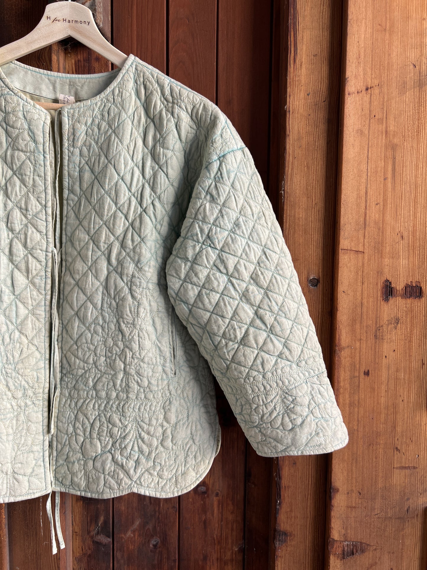 Green quilted jacket hanging on a wooden door