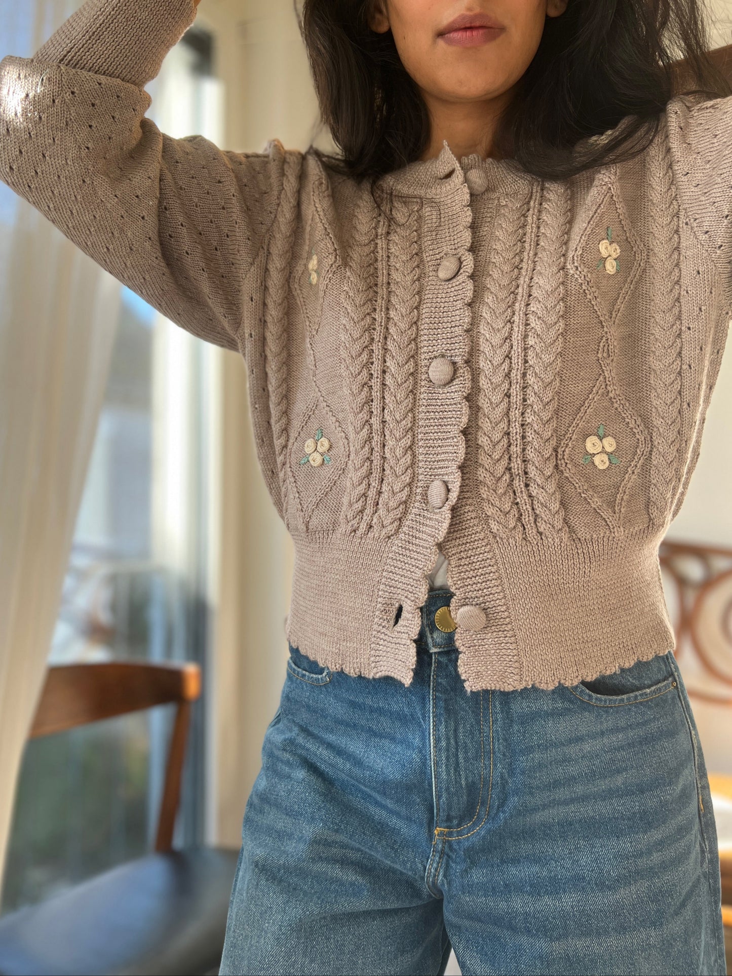 Sienna Cardigan in organic merino wool with knitted cables, pointelle details, and hand-embroidered flowers.