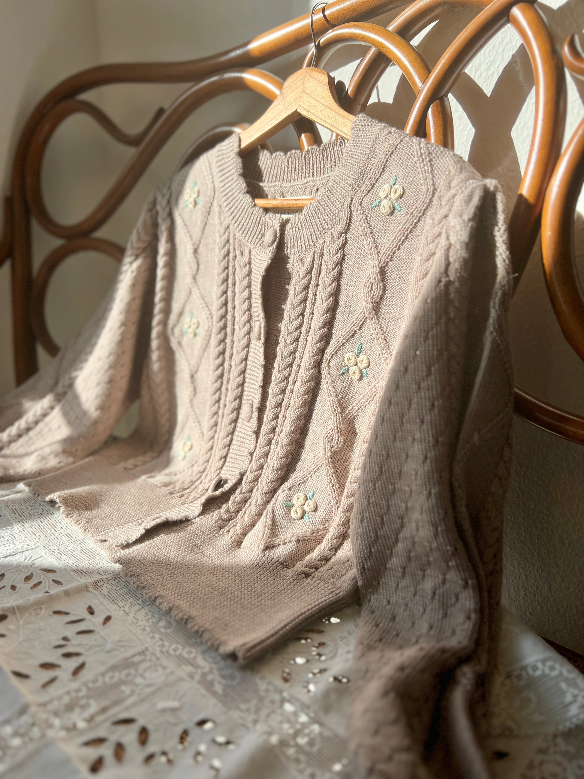 Sienna Cardigan in organic merino wool, featuring cable knit, pointelle details, and embroidered flowers.